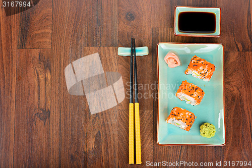 Image of Sushi rolls on the wooden table. View from above