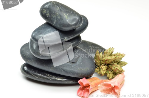Image of Stack of black stones with fake flowers