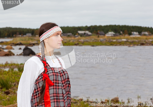 Image of girl in national dress at the sea shore