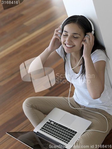 Image of relaxed young woman at home working on laptop computer
