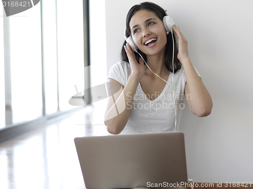 Image of relaxed young woman at home working on laptop computer