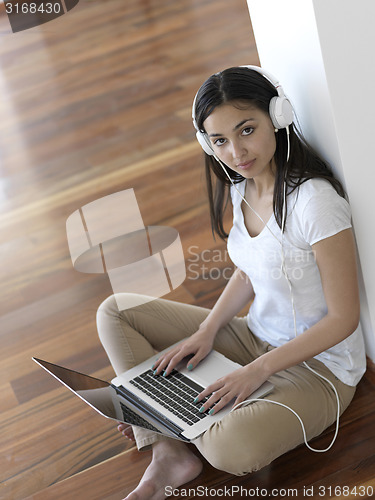 Image of relaxed young woman at home working on laptop computer