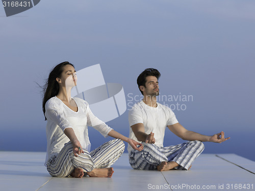 Image of young couple practicing yoga