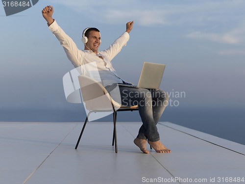 Image of relaxed young man at home on balcony