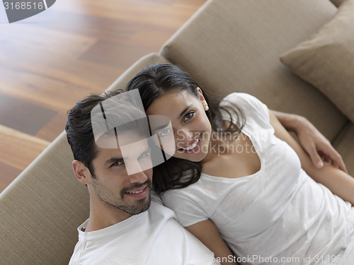 Image of relaxed young couple working on laptop computer at home