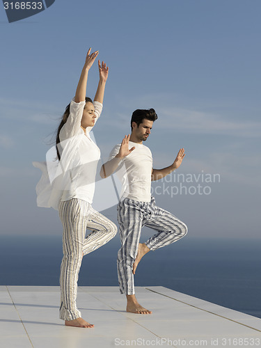 Image of young couple practicing yoga