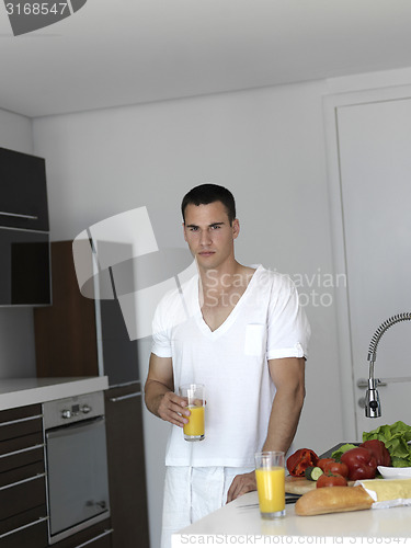 Image of man cooking at home preparing salad in kitchen