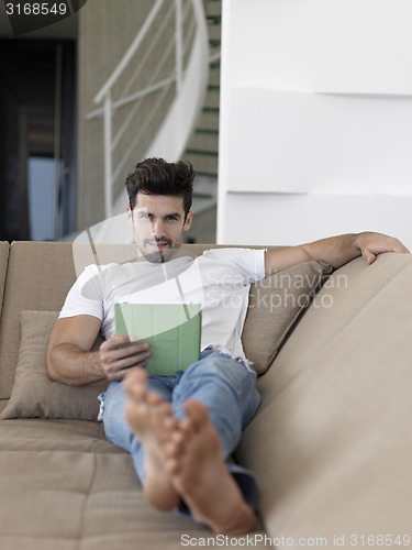 Image of man using tablet computer from home