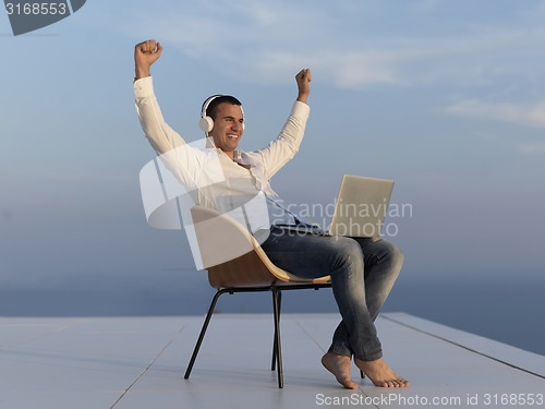Image of relaxed young man at home on balcony