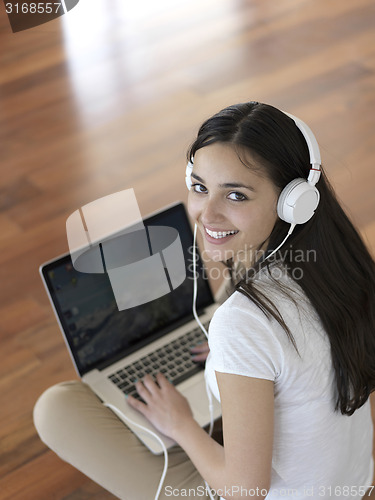 Image of relaxed young woman at home working on laptop computer