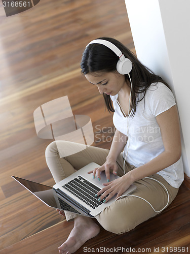Image of relaxed young woman at home working on laptop computer