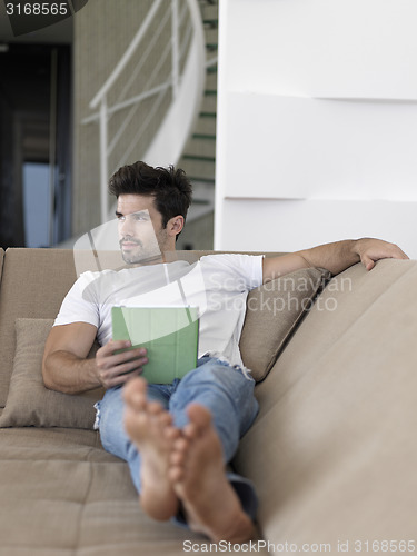 Image of man using tablet computer from home