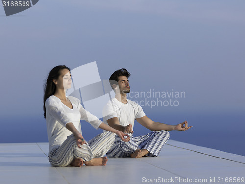 Image of young couple practicing yoga