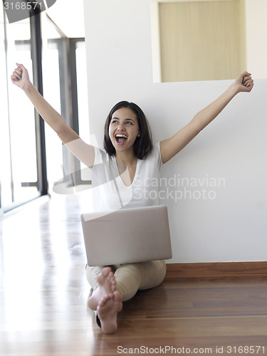 Image of relaxed young woman at home working on laptop computer