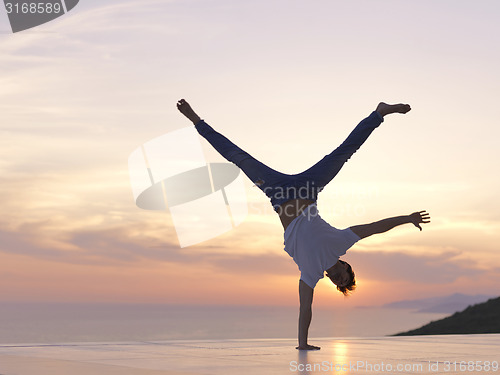 Image of relaxed young man at home on balcony