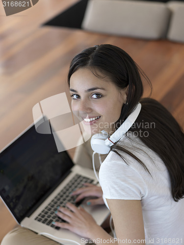 Image of relaxed young woman at home working on laptop computer