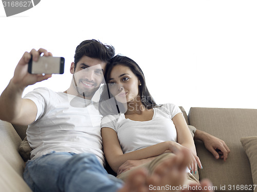 Image of young couple making selfie together at home