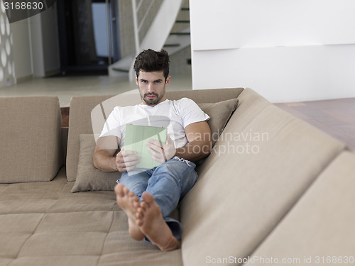 Image of man using tablet computer from home