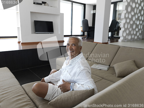 Image of Portrait of senior man relaxing in sofa