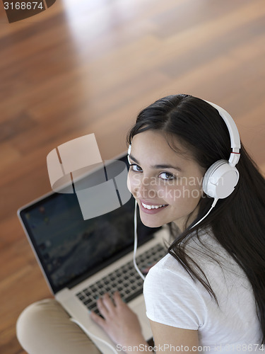 Image of relaxed young woman at home working on laptop computer