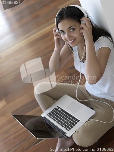 Image of relaxed young woman at home working on laptop computer