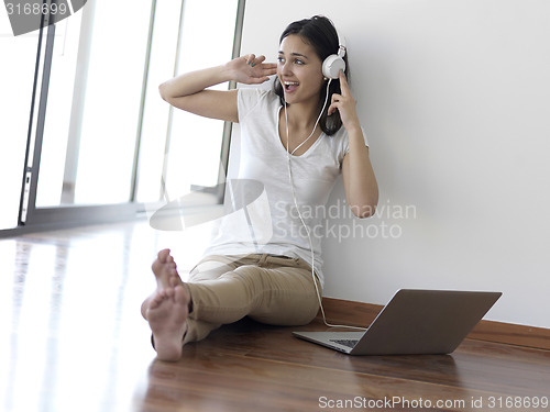 Image of relaxed young woman at home working on laptop computer