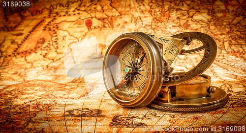 Image of Vintage compass lies on an ancient world map.