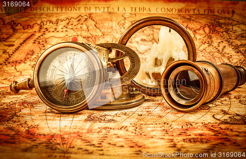 Image of Vintage magnifying glass lies on an ancient world map