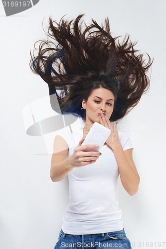 Image of Woman lying on her back and using phone