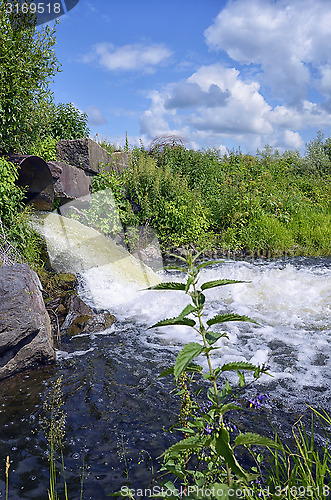 Image of Discharge of water from a metal pipe in the river