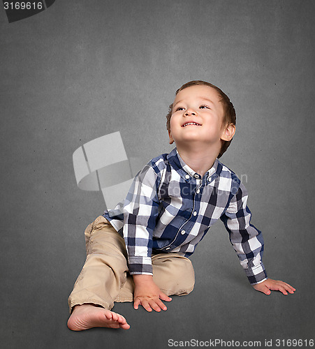 Image of Cute boy siting on the floor