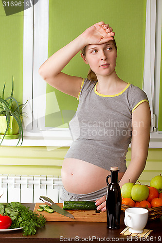 Image of Pregnant woman on kitchen cooking