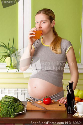 Image of Pregnant woman on kitchen cooking