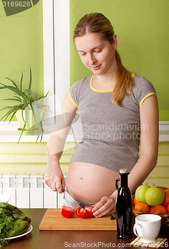 Image of Pregnant woman on kitchen cooking