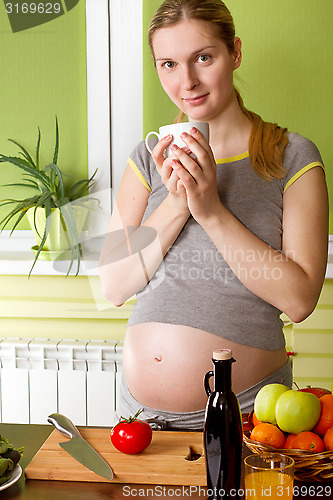 Image of Pregnant woman on kitchen cooking