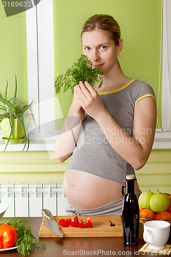 Image of Pregnant woman on kitchen cooking