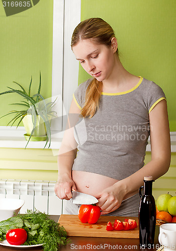 Image of Pregnant woman on kitchen cooking