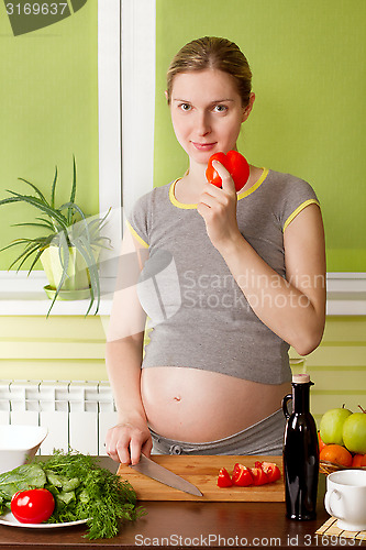 Image of Pregnant woman on kitchen cooking