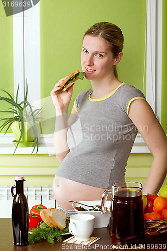 Image of Pregnant woman on kitchen cooking