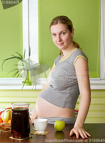 Image of Pregnant woman on kitchen cooking