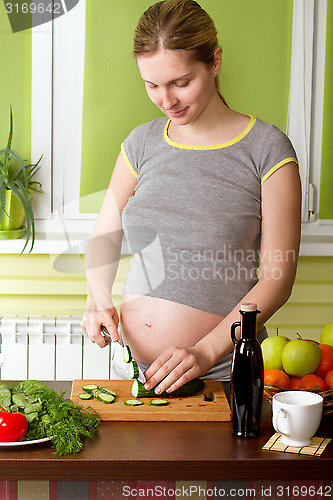 Image of Pregnant woman on kitchen cooking