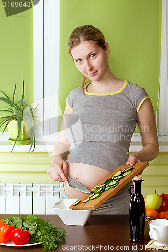 Image of Pregnant woman on kitchen cooking