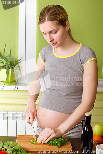 Image of Pregnant woman on kitchen cooking