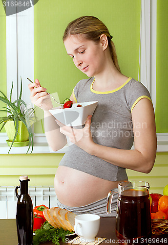 Image of Pregnant woman on kitchen cooking