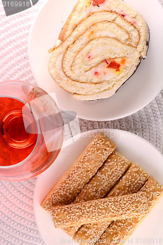 Image of sweet cake on white plate and red wine