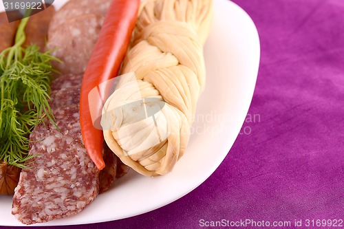 Image of salami with pieces of cheese and red pepper