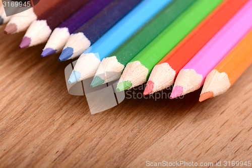 Image of colored pencils  on wooden background