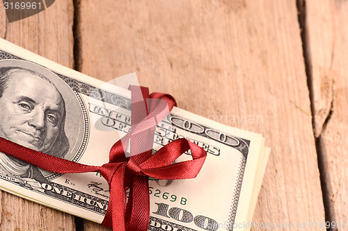 Image of dollars wraped up with a red ribbon isolated on white background