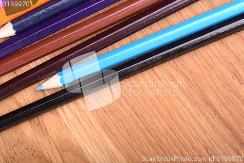 Image of colored pencils  on wooden background