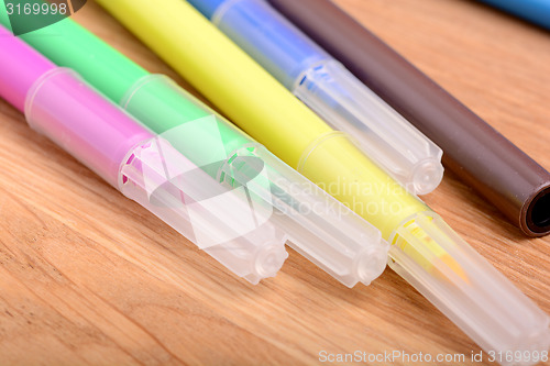 Image of Blank notebook with many color markers on wooden table. The view from the top